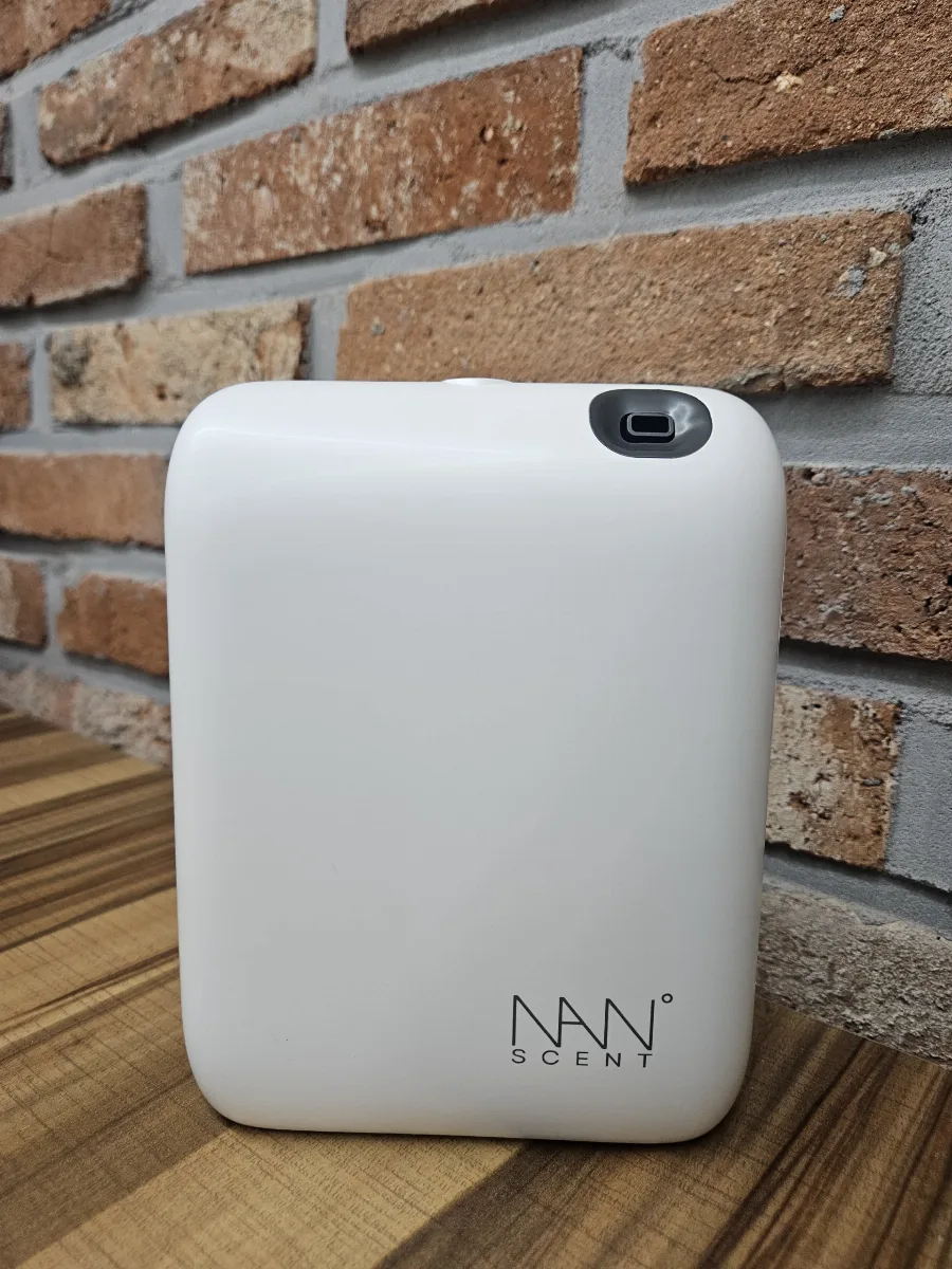 벽돌 벽 앞에 놓인 화이트 전자디퓨저 NANO-20V 회의실 배치 예시